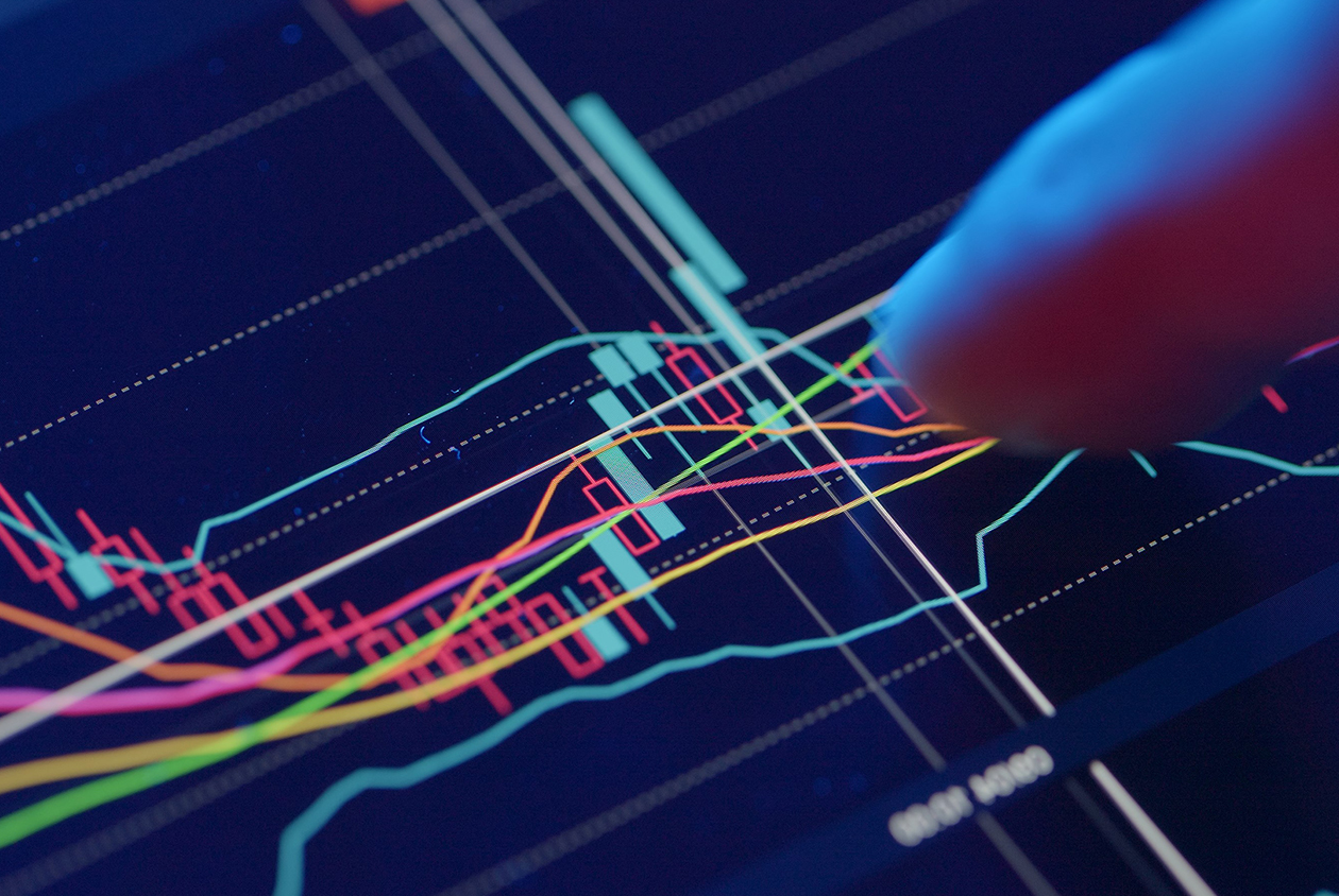 Uomo che lavora su una tastiera virtuale a dei grafici di trading online