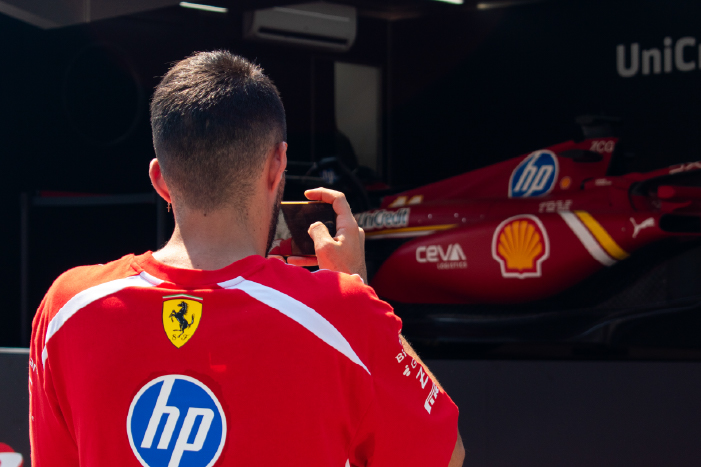 A person taking a picture of a Ferrari car