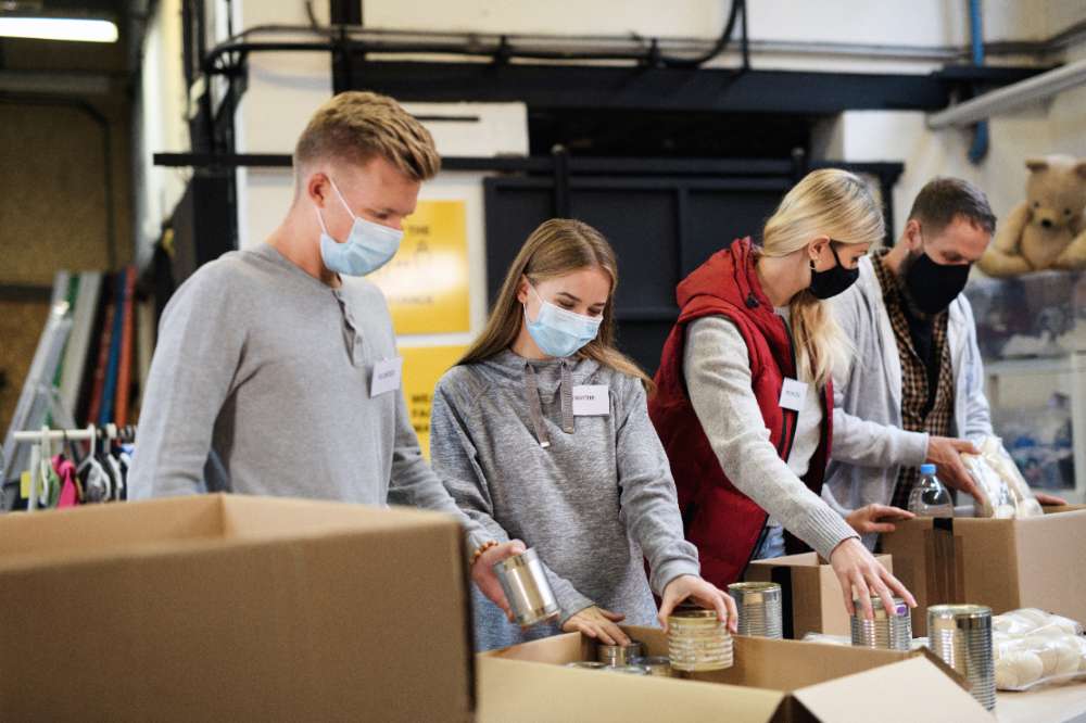 Group of volunteers in community charity donation center, food bank and coronavirus concept. Group of volunteers working in community charity donation center, food bank and coronavirus concept.