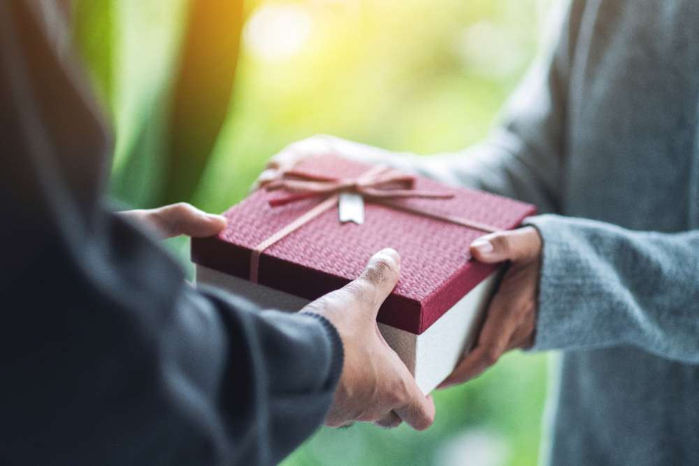 Closeup image of a man giving a woman a gift box Closeup image of a man giving a woman a gift box
