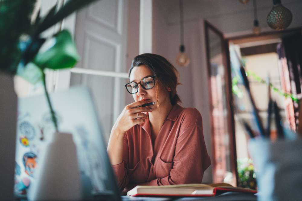 Young businesswoman thinking about something while sitting front open portable laptop computer reading email from client, long hours of work concept Young businesswoman thinking about something while sitting front open portable laptop computer reading email from client, long hours of work concept